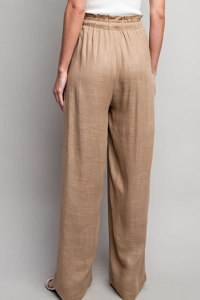 Indulge in the ultimate comfort and style with our Coco Linen Wide Leg Pants. These high waisted pants are designed with a smocked waist and waist tie for a flattering fit, while the side pockets add convenience. Perfect for both casual and dressy occasions, these pants will elevate your wardrobe. Product Details: 65% Rayon, 35% Linen Model is 5'8" and wearing a small