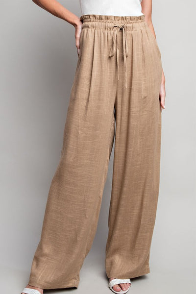 Indulge in the ultimate comfort and style with our Coco Linen Wide Leg Pants. These high waisted pants are designed with a smocked waist and waist tie for a flattering fit, while the side pockets add convenience. Perfect for both casual and dressy occasions, these pants will elevate your wardrobe. Product Details: 65% Rayon, 35% Linen Model is 5'8" and wearing a small