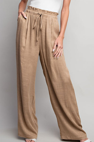Indulge in the ultimate comfort and style with our Coco Linen Wide Leg Pants. These high waisted pants are designed with a smocked waist and waist tie for a flattering fit, while the side pockets add convenience. Perfect for both casual and dressy occasions, these pants will elevate your wardrobe. Product Details: 65% Rayon, 35% Linen Model is 5'8" and wearing a small
