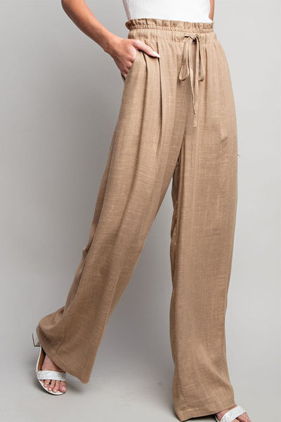 Indulge in the ultimate comfort and style with our Coco Linen Wide Leg Pants. These high waisted pants are designed with a smocked waist and waist tie for a flattering fit, while the side pockets add convenience. Perfect for both casual and dressy occasions, these pants will elevate your wardrobe. Product Details: 65% Rayon, 35% Linen Model is 5'8" and wearing a small