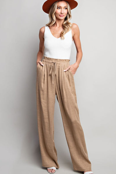 Indulge in the ultimate comfort and style with our Coco Linen Wide Leg Pants. These high waisted pants are designed with a smocked waist and waist tie for a flattering fit, while the side pockets add convenience. Perfect for both casual and dressy occasions, these pants will elevate your wardrobe. Product Details: 65% Rayon, 35% Linen Model is 5'8" and wearing a small