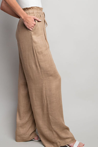 Indulge in the ultimate comfort and style with our Coco Linen Wide Leg Pants. These high waisted pants are designed with a smocked waist and waist tie for a flattering fit, while the side pockets add convenience. Perfect for both casual and dressy occasions, these pants will elevate your wardrobe. Product Details: 65% Rayon, 35% Linen Model is 5'8" and wearing a small