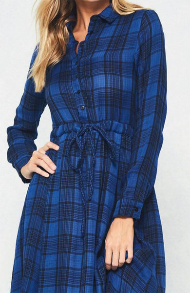 A blue and black plaid pattern shirt dress featuring basic collar, button front, self-tie waist, long sleeves and hi-lo hem. This dress is made with medium weight fabric that has very beautiful patterns.