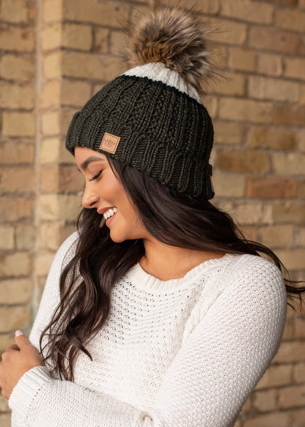 Can't decide on one color, try this green and cream color block hat accented with a black stripe. Fleece lined to keep your head extra warm. Product Details: Knit hat Large faux fur pom detail