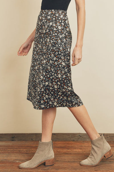 Fresh, fun, floral printed midi skirt. Featuring a silky black satin fabric with an elastic waistband on the back and a hidden back zipper closure. Product Details: 100% Polyester Model is 5'9" and wearing size Small.