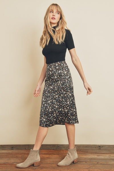 Fresh, fun, floral printed midi skirt. Featuring a silky black satin fabric with an elastic waistband on the back and a hidden back zipper closure. Product Details: 100% Polyester Model is 5'9" and wearing size Small.
