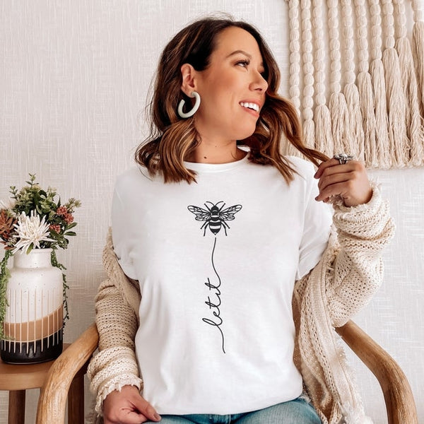 Let your top do the talking ! The Let It Bee shirt is a fan favorite and a great addition to your every day wardrobe. This cutie comes in colors white and orchid. Product Details: Unisex Cut Tee (Bella + Canvas brand top) Hand screen printed in the US Cotton & Poly Blend Machine Wash