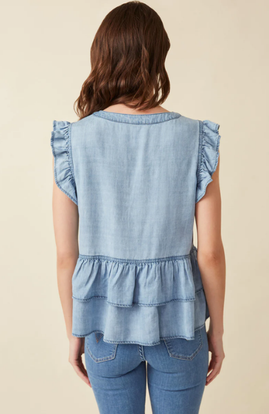 This light denim sleeveless top keeps you cool and stylish in warm weather. Featuring flutter ruffle sleeves, with tiered ruffles silhouette and button details. Style with white denim for a summer must-have outfit. Product Details: 100% Tencel Sleeveless top Woven Denim Fabric Button Details Ruffle Details Hand wash cold