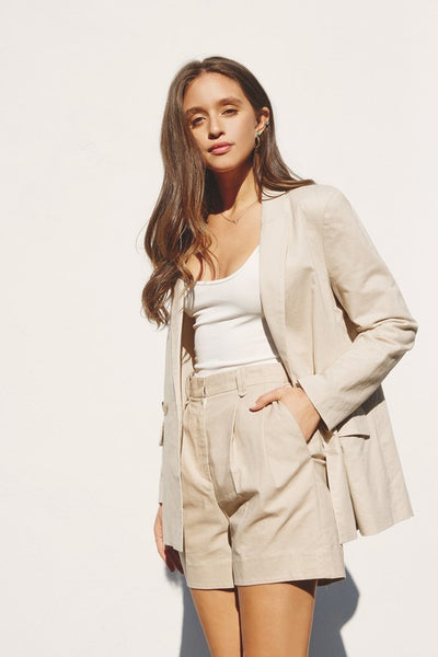 Cotton and linen blend shorts with a pleated front lending to a tailored look. Featuring a high waist, belt loops, side pockets, and a zipper and a hook and eye closure. Fitted at the waist with relaxed style. Pair with the matching At Leisure Blazer! Product Details: Shell 55% cotton, 45% linen Lining: 100% cotton Lined Model is 5'9" and wearing a size small Pair with matching At Leisure Blazer