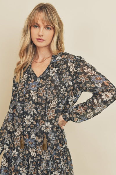 How cute is this black paisley floral print swing dress with long sleeves. There is a tasseled string detail on the neckline and ruffle detailing on the shoulders. Product Detail: 100% Polyester Loose fit Fully lined Model is 5'9" and wearing size Small.