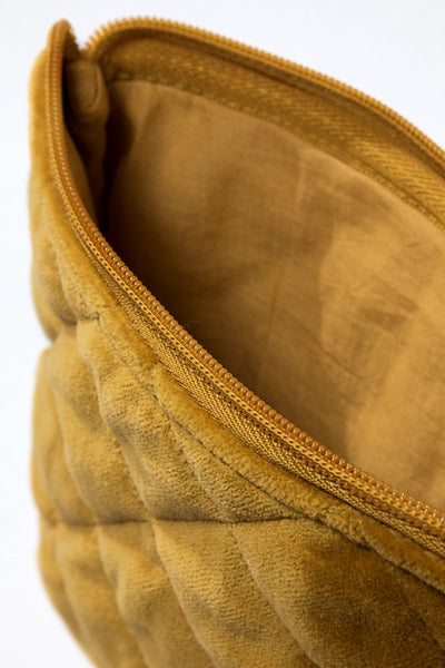 How cute is this quilted pouch! The cotton velvet material gives it a luxurious feel that you'll never want to put it down. With fun details including metallic stitching and tassel accent. Product Details: Shell 100% cotton and trim 100% acrylic Approximate length - 6.5" and width - 9" Zipper closure Comes in a mustard and gray color