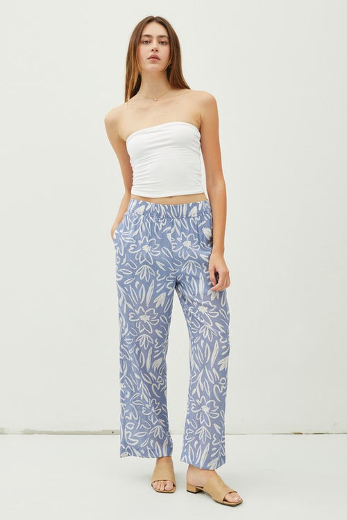 Glide through your day with ease and style in our Slate Flower Print Pants! The lightweight, double-lined fabric and elastic waistband provide ultimate comfort, while the ankle length and high waist give a flattering fit. With a breezy wide leg and convenient pockets, these pants are a delight!  Product Details:   85% Rayon, 15% Nylon Ankle length Wide leg High waist Lined to upper thigh Inseam: 27", Rise 12 1/2" Model is wearing a small