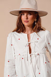 Fall in love with the romantic charm of this ivory blouse, adorned with delicate red heart embroidery that adds a playful pop of color. Featuring an elegant front-tie detail and feminine puff sleeves, this top strikes the perfect balance between sweet and sophisticated. The lightweight fabric drapes beautifully, making it ideal for date nights, casual outings, or festive occasions. Pair it with your favorite jeans, skirts, or tailored trousers to create a look that’s effortlessly chic and full of love!