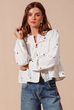 Fall in love with the romantic charm of this ivory blouse, adorned with delicate red heart embroidery that adds a playful pop of color. Featuring an elegant front-tie detail and feminine puff sleeves, this top strikes the perfect balance between sweet and sophisticated. The lightweight fabric drapes beautifully, making it ideal for date nights, casual outings, or festive occasions. Pair it with your favorite jeans, skirts, or tailored trousers to create a look that’s effortlessly chic and full of love!