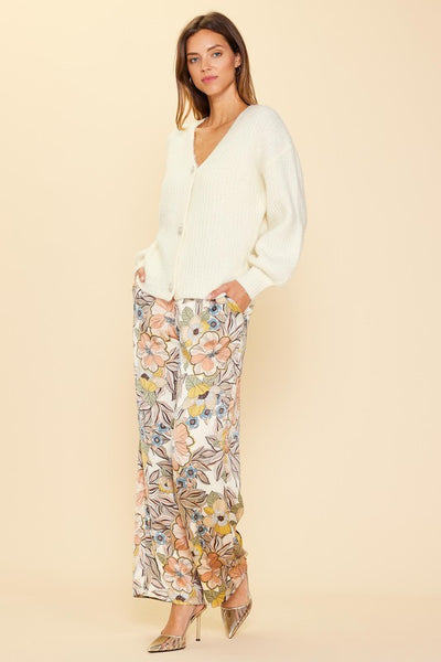Step out in style wearing our Fall Floral Pant. Crafted from a luxurious cream satin fabric, adorned with a delicate floral print, and finished with a tie waist for a timeless tailored look, these wide leg pants will add a subtle yet chic touch to any outfit.  Product Details:  100% Polyester