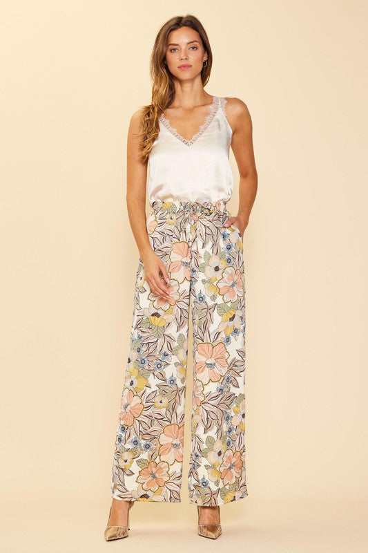 Step out in style wearing our Fall Floral Pant. Crafted from a luxurious cream satin fabric, adorned with a delicate floral print, and finished with a tie waist for a timeless tailored look, these wide leg pants will add a subtle yet chic touch to any outfit.  Product Details:  100% Polyester