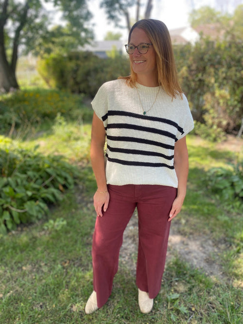 Get cozy and chic with our Ivory and Black Stripe Sweater Top! This high neck top features short sleeves, which can be won alone or pair with a long sleeve top underneath. This classic striped top is perfect for any occasion.,&nbsp;