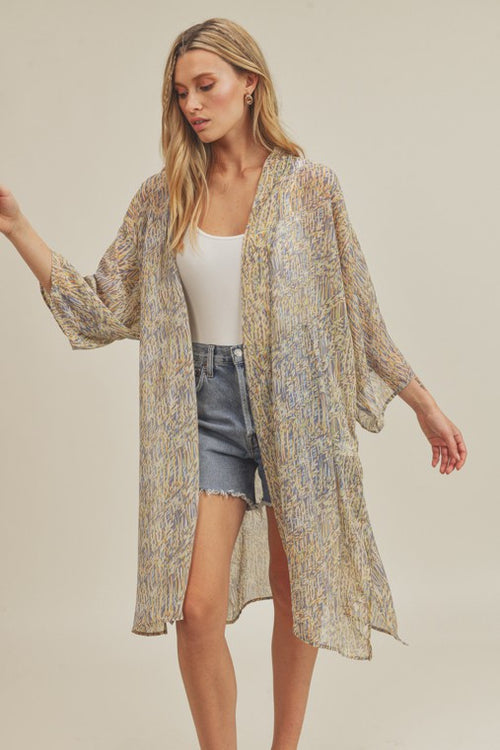 Don't forget this open front kimono cardigan for your next vacay or weekend getaway. Designed with three-quarter sleeves and flattering longer length that hits at knee. A mixture of blues, greens and oranges highlights this kimono.  Product Details:  Open front  Slit side details Light weight Loose fitting