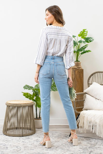 Feel carefree in this airy blue striped top. Featuring a split v-neckline with button detail, along with 3/4 roll tab sleeves. A warm weather approved top!  Product Details:   99.5% Cotton, .5% Spandex  Lightweight Sheer V-neckline with button detail 3/4 sleeves Roll tab sleeves