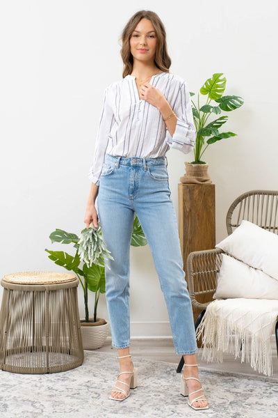 Feel carefree in this airy blue striped top. Featuring a split v-neckline with button detail, along with 3/4 roll tab sleeves. A warm weather approved top!  Product Details:   99.5% Cotton, .5% Spandex  Lightweight Sheer V-neckline with button detail 3/4 sleeves Roll tab sleeves