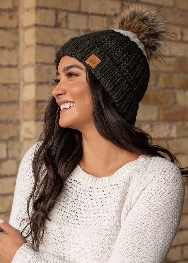 Can't decide on one color, try this green and cream color block hat accented with a black stripe. Fleece lined to keep your head extra warm.  Product Details: Knit hat Large faux fur pom detail
