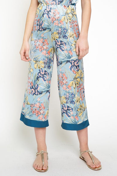 The cropped wide leg pant is alive and well and ready to become apart of your must-have summer style. Satin smooth and stunning blue floral print is a show stopper. Style with matching floral cami or pair with a white linen button down for a different vibe!  Product Details:  100% Polyester  Cropped, midi length Elastic waist Contrast trim hem Fits true to size Model wears size small & is 5'9"