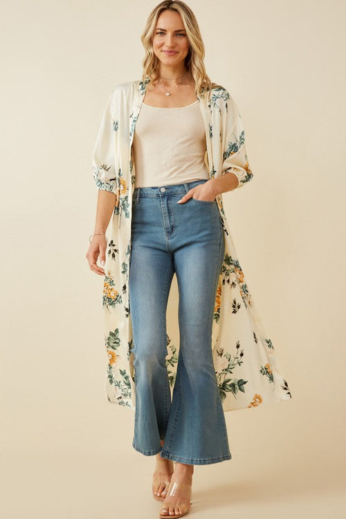 Absolutely stunning is a perfect description of this satin floral duster. Pair with a orange tank and wide leg jeans for the perfect look.   Product Details:  100% Polyester Ivory floral woven fabric Open front Cuff Sleeve