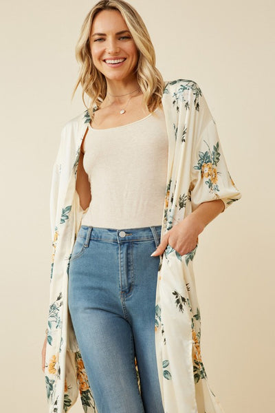 Absolutely stunning is a perfect description of this satin floral duster. Pair with a orange tank and wide leg jeans for the perfect look.   Product Details:  100% Polyester Ivory floral woven fabric Open front Cuff Sleeve