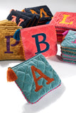 How cute are these vibrant hand embroidered initial pouches. With lurex and velvet quilt fabric and featuring pipping detail. They are fully lined with a tassel zipper closure.  Product Details:  They come in initials - A, E, K, L, M, N, R & S 100% Cotton Velvet Approximately 7