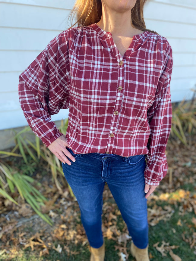 Chic burgundy and white plaid top that screams cooler weather look!  Super flattering collarless, split neck style with balloon sleeves.   Product Details:  60% Polyester, 30% Cotton, 10% Viscose Billowing sleeves Long sleeve Button front
