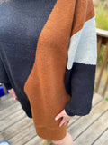 This classic turtleneck style sweater dress will keep you stylish and warm! Featuring black, rust and ivory color block design. Pair with tights and some booties and you'll be ready to go!  Product Details  43% Acrylic, 29% Nylon, 28% Polyester Boxy, straight silhouette Thick sweater knit material Long balloon sleeves Split side hems