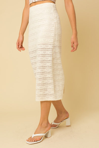 The next sunny day calls for this ivory lace skirt. The intricate lace detail elevates this look and is perfect for a summer event. Lined half way and completed with a sheer lace to hem. Pair with matching top or add a pop of color, so many styling options.  Product Details:  95% Polyester, 5% Spandex Lining 100% Polyester Half lined Zip closure Midi length Back slit