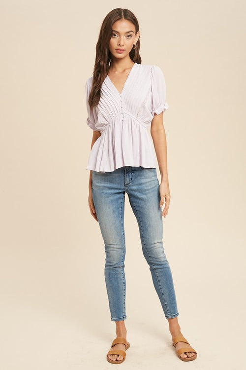 This delicate lilac v neck blouse exudes a feminine, classy vibe. With eye-catching details that include lace trim, button down front and flattering peplum style. The pintuck pleat design on the bodice sets this top apart.    Product Details:  100% Rayon, Lace 100% Cotton Pintuck pleat design Front button down closure Ruffle sleeve