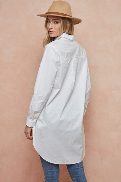 We love the ease of this white button down tunic shirt. Simple, classic style that works great with leggings or jeans.   Product Details:  100% Cotton  Length 37", sleeve length 24" Poplin weave Long sleeve, collar