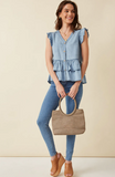This light denim sleeveless top keeps you cool and stylish in warm weather. Featuring flutter ruffle sleeves, with tiered ruffles silhouette and button details. Style with white denim for a summer must-have outfit.   Product Details:  100% Tencel Sleeveless top Woven Denim Fabric Button Details Ruffle Details Hand wash cold