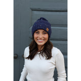 Keep your melon warm in this fleece lined navy speckled hat. Featuring a fun pom pom at the top and attractive large braided knit pattern.  Product Details:  90% Acrylic, 10% Polyester, Lining 100% Polyester Fold down cuff Comfy fleece lining