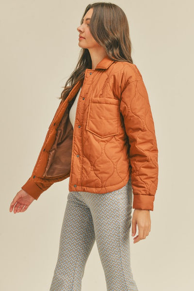 This roasted pecan quilted puffer jacket screams Fall! A perfect transitional piece featuring a boxy fit along with front patch pockets and snap front closure. An absolute essential this season!   Product Features:  100% Nylon Lined Front patch pockets Snap button closure Long sleeves with snap button cuffs Shirttail hem Model is 5' 9" 32-24.5-34.5 and wearing a small