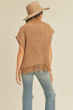 This sleeveless taupe fringe poncho vest has a slight boho vibe. Featuring a mock neck and open at the sides with button closure. Pair with a long sleeve top as the temperatures dip and your favorite pair of jeans.   Product Details:  Fabric is 100% Acrylic Ribbed high neckline Fringe hem Side button closure Boxy silhouette Model is 5' 9